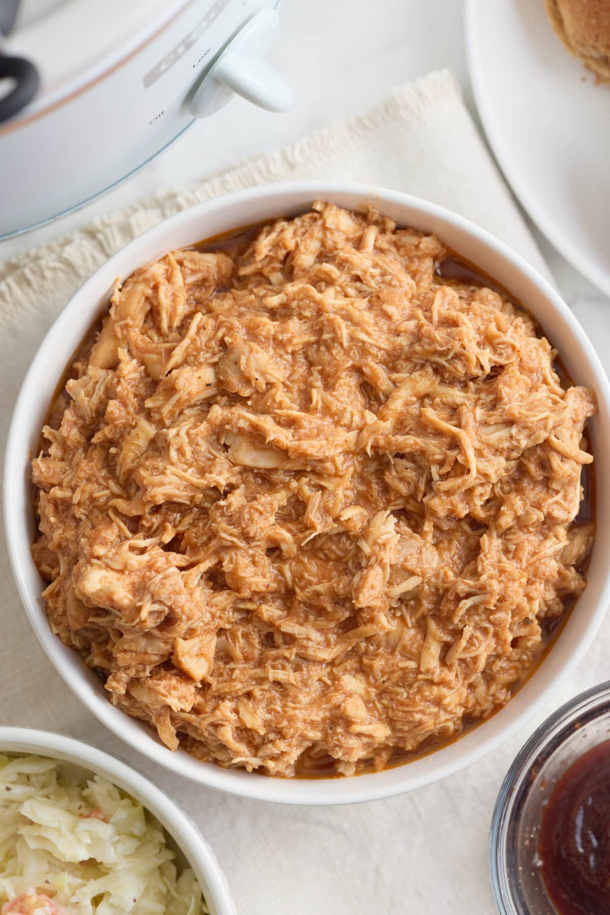 A serving bowl full of shredded bbq chicken.