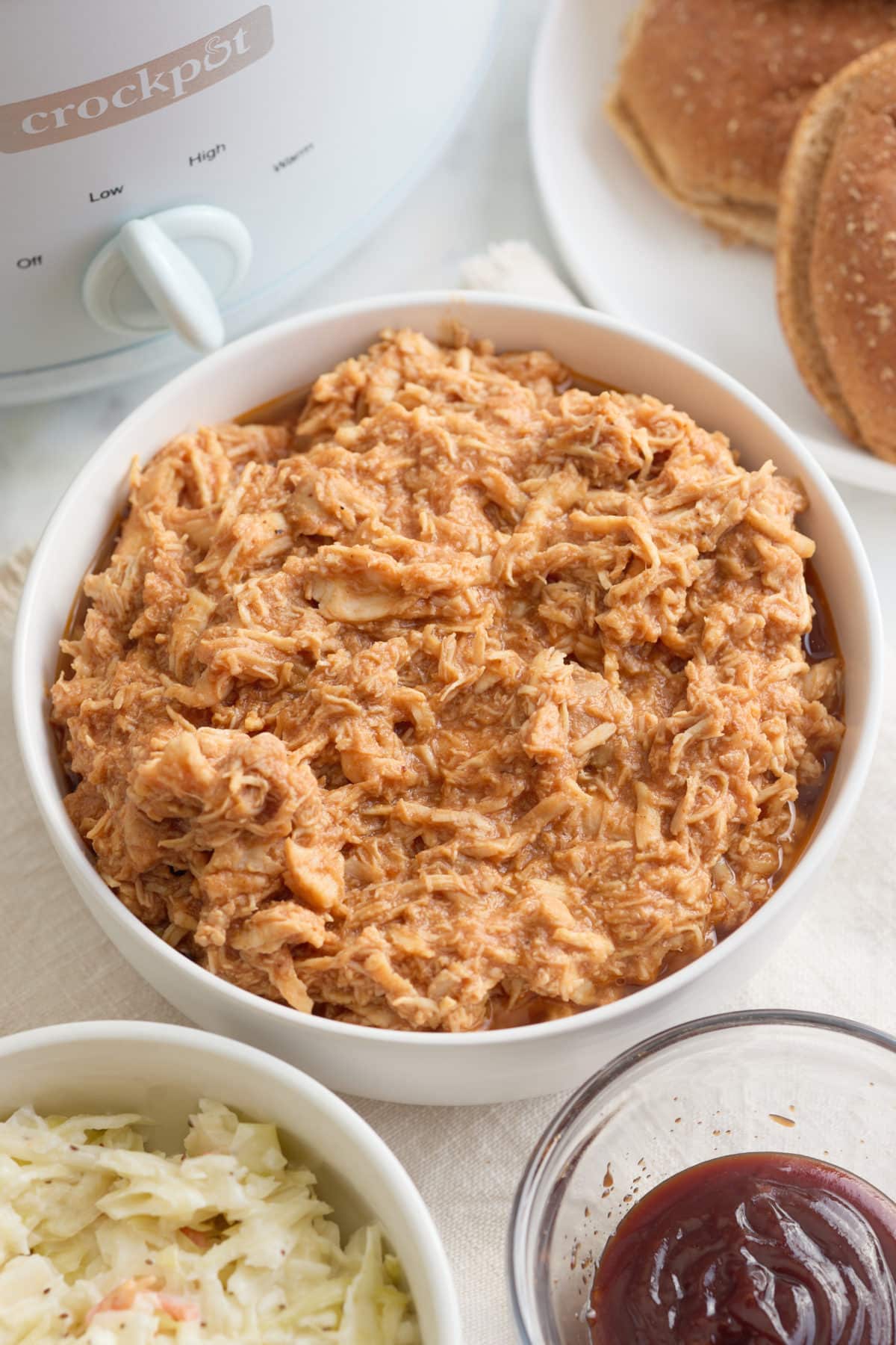 A serving bowl full of shredded bbq chicken.