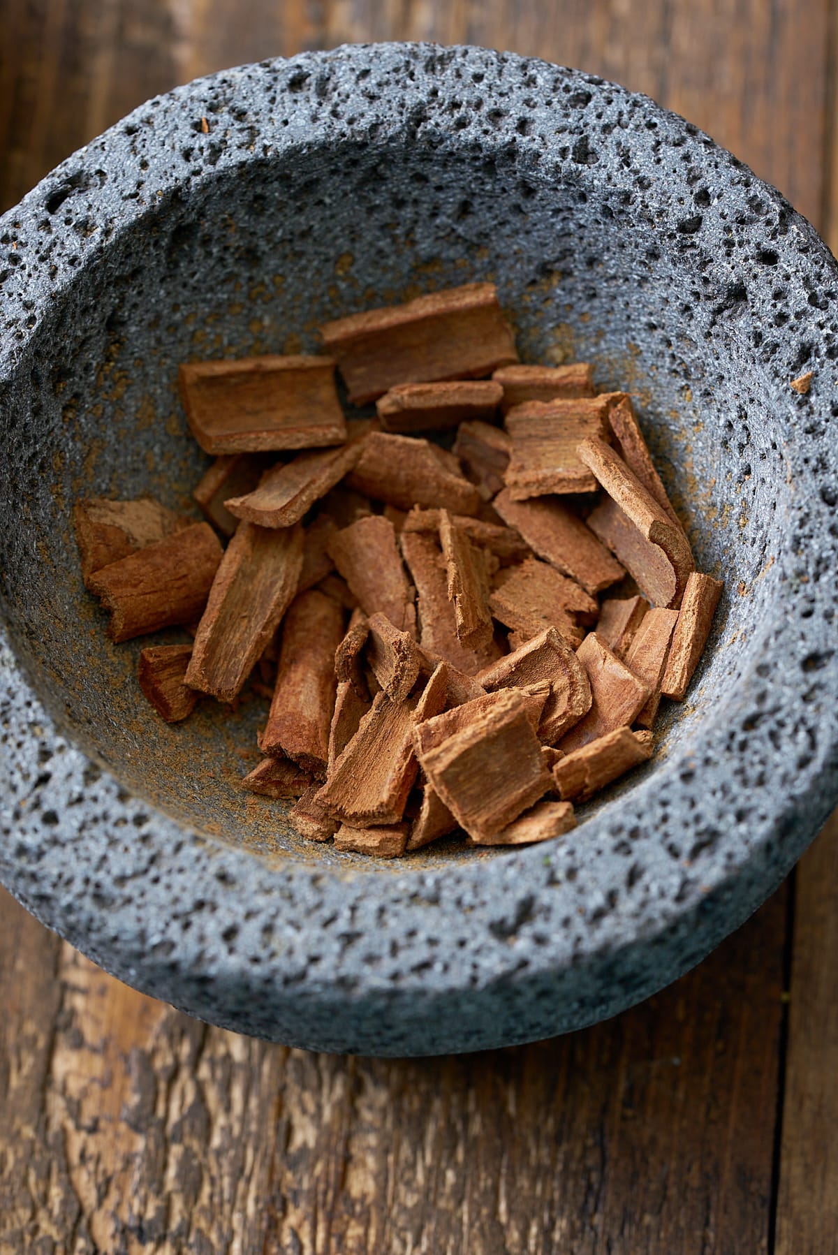 A pestle and mortar filled with crushed cinnamon sticks.