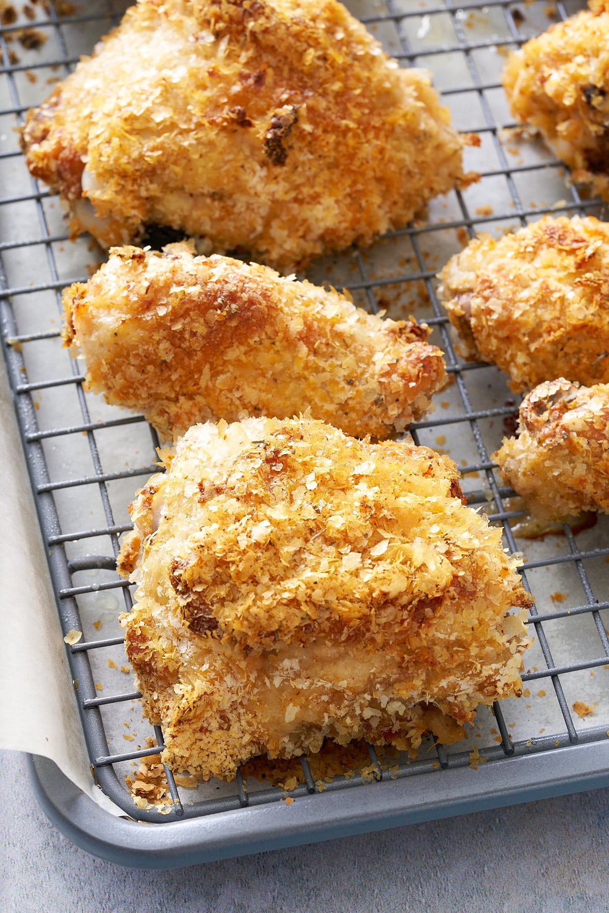 Pieces of crispy crumbed chicken on a wire rack.