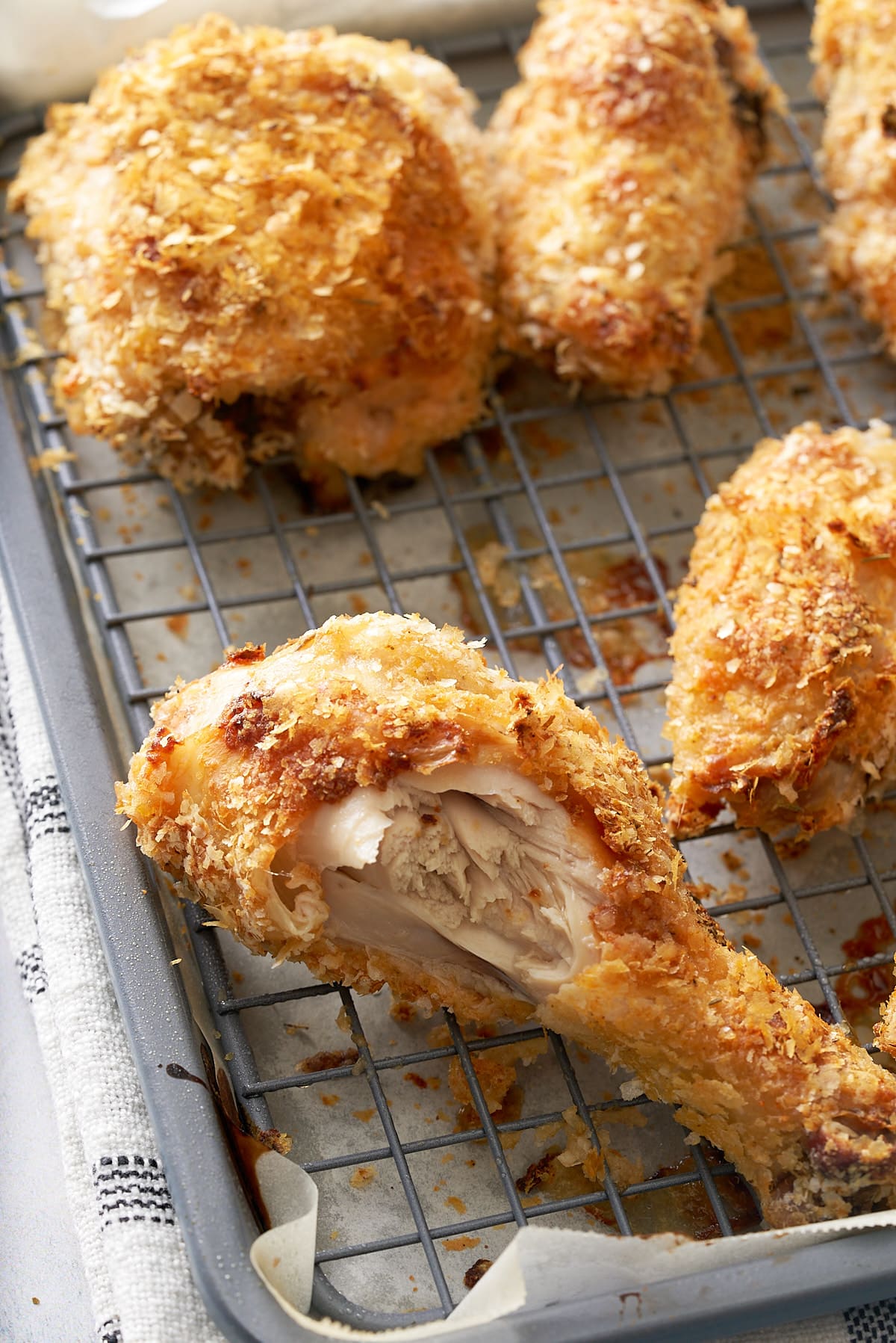 Wire rack set into a baking tray with pieces of crispy cooked chicken on top.