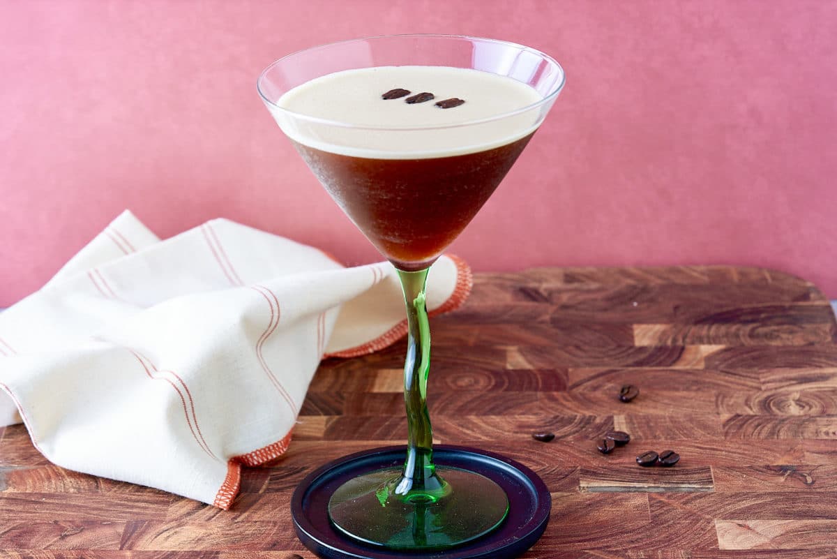 Prepared espresso martini with coffee bean garnish.