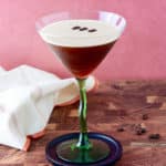 Prepared espresso martini with coffee bean garnish.