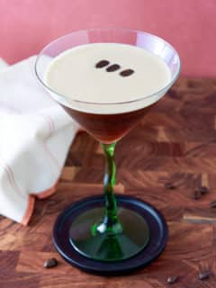 Prepared espresso martini with coffee bean garnish.