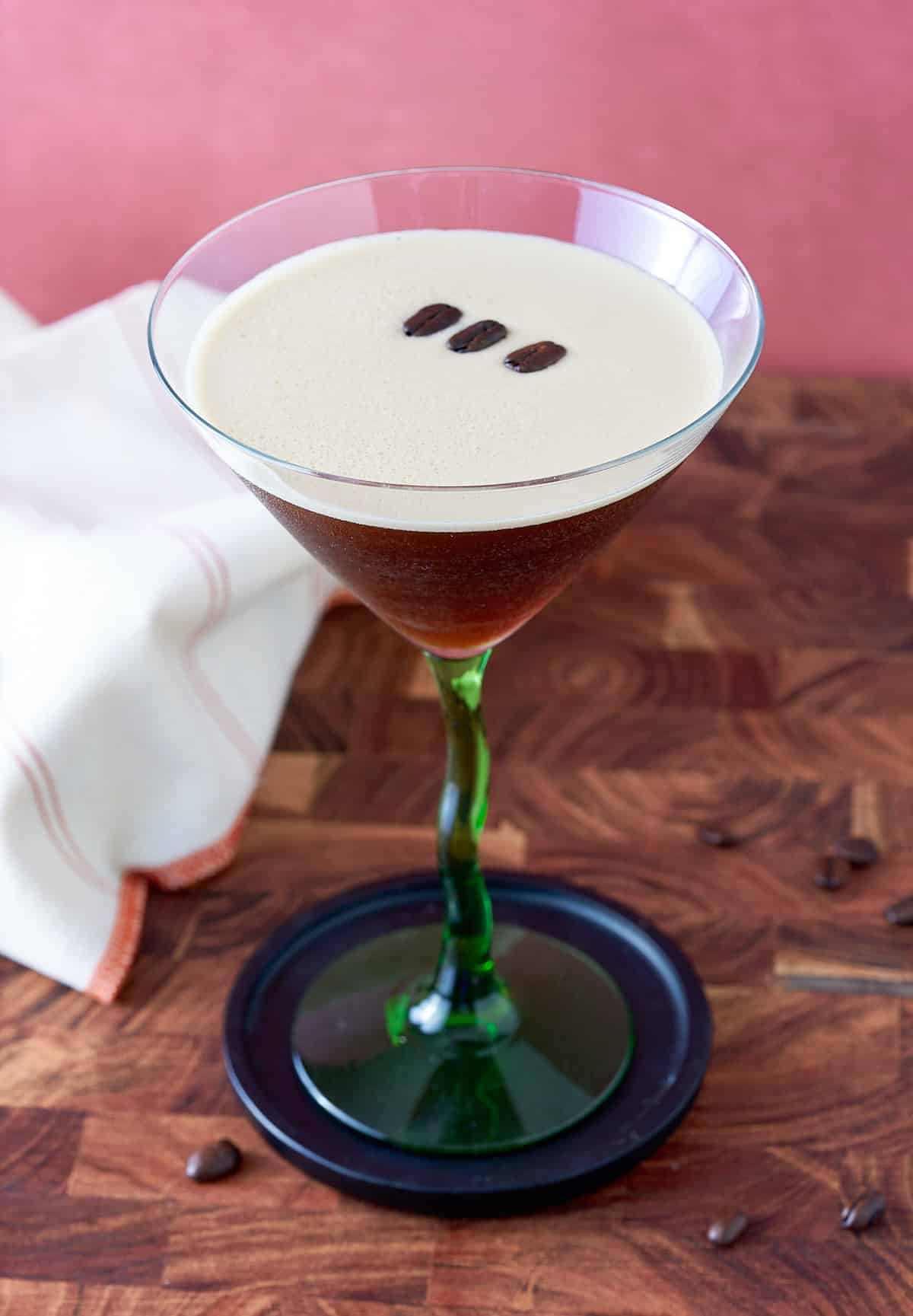 Prepared espresso martini with coffee bean garnish.