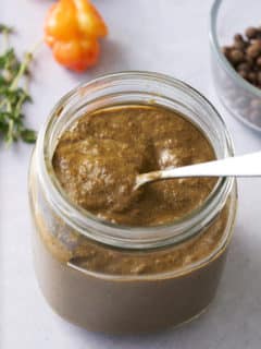 The marinade in a jar with a spoon taking some out.