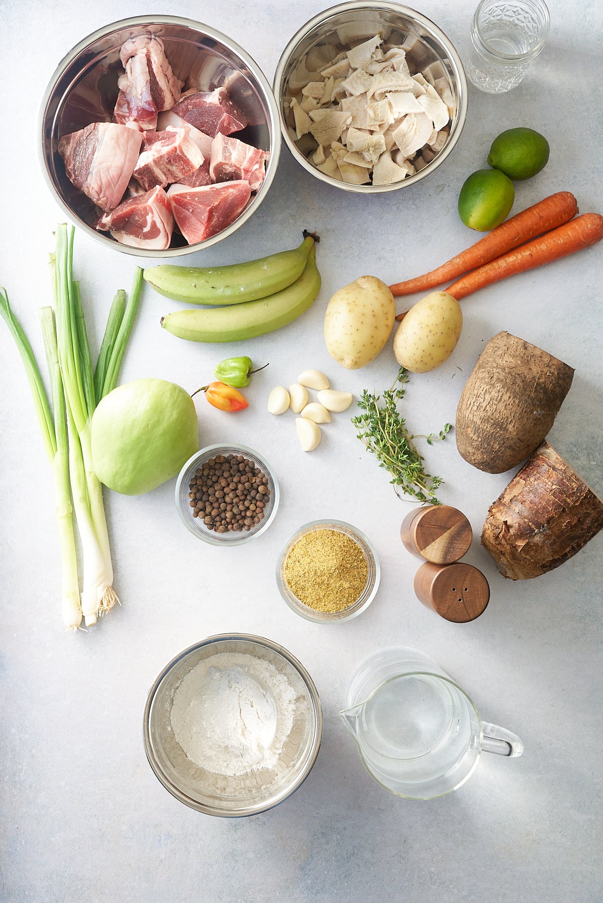 A variety of recipe ingredients including meat, vegetables, spices and herbs, along with flour and water.