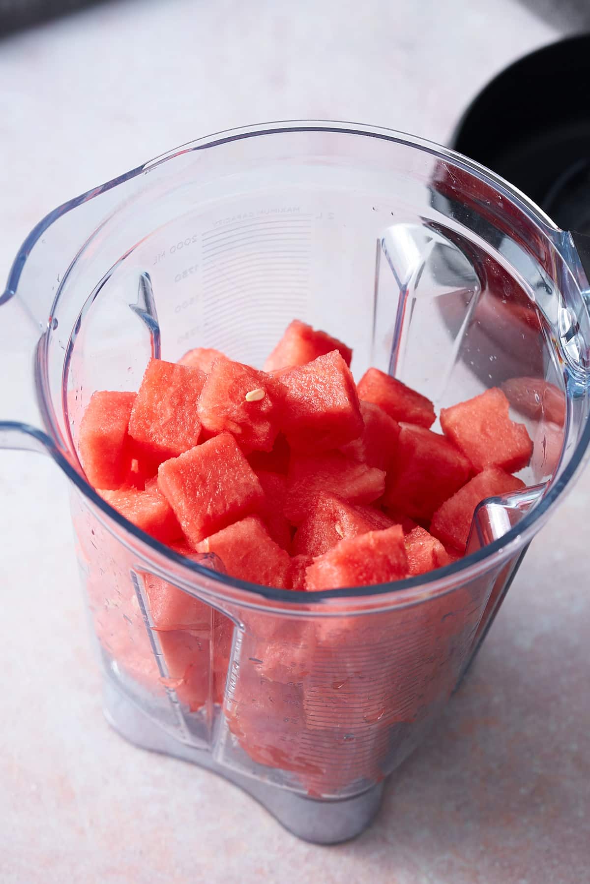 A blender jug filled with diced watermelon.