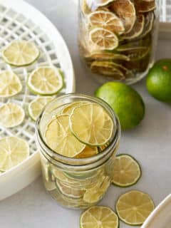 dehydrated limes in glass container with other limes around