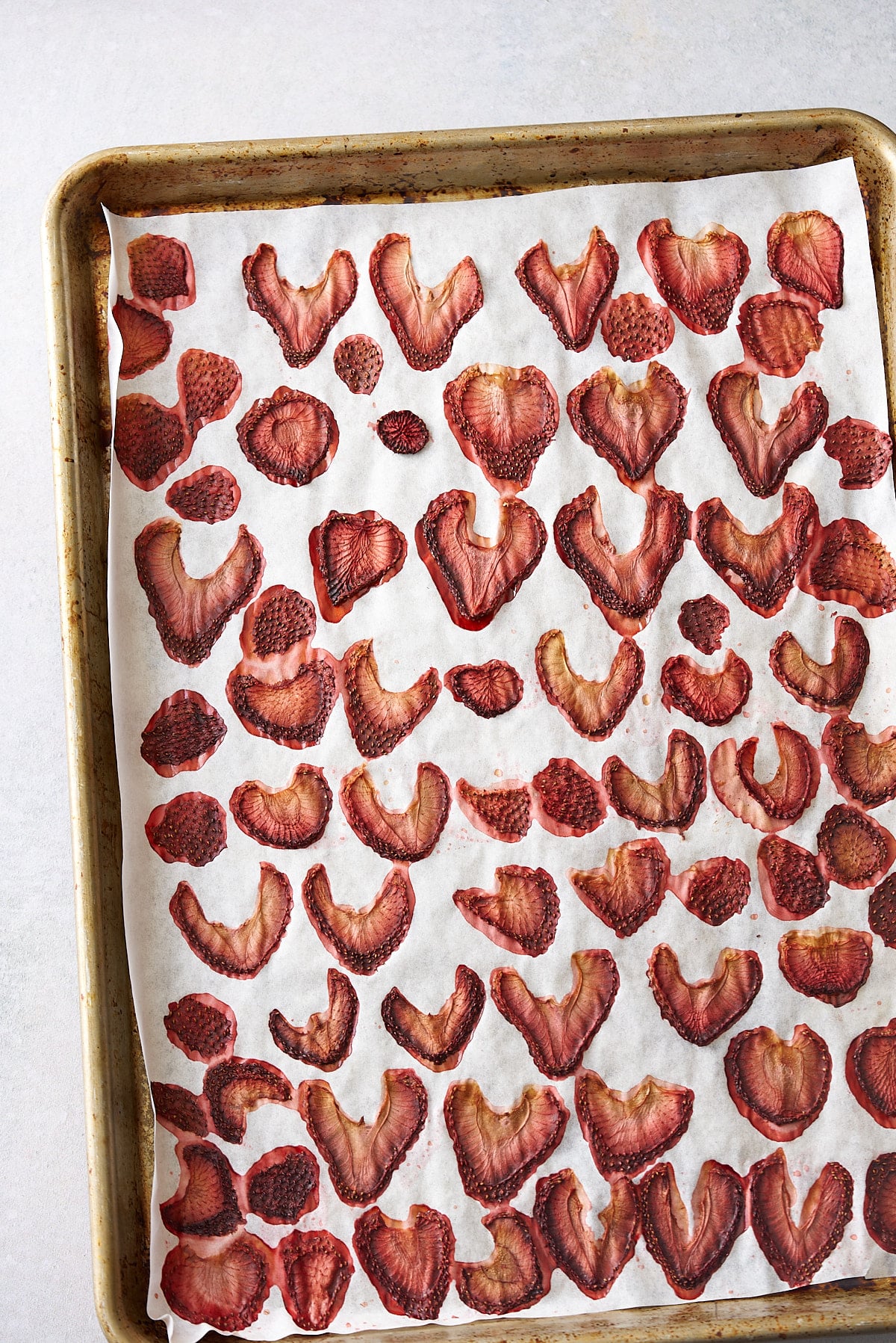 dehydrated strawberries on parchment paper after dehydrating in oven