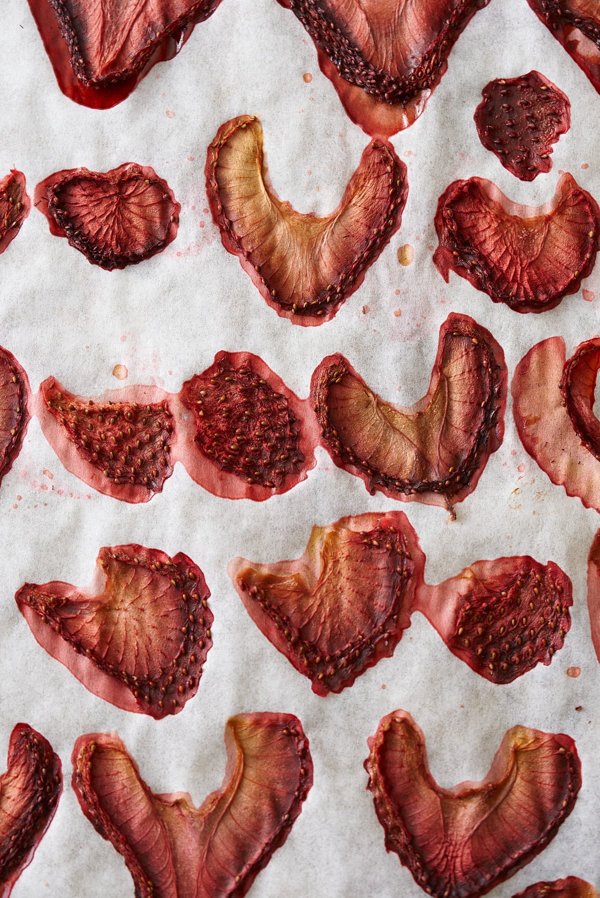 close up photo of dehydrated strawberries on parchment paper