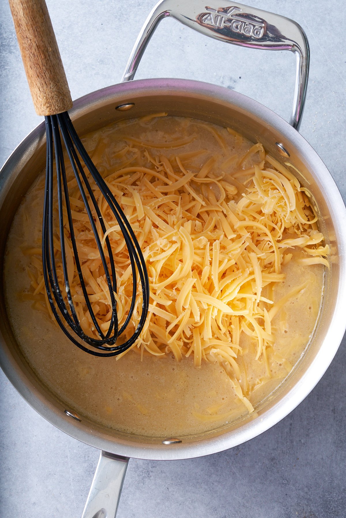 cheese added to pan along with roux, beer, and milk and whisk in pan