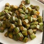 A white serving platter with roasted okra.