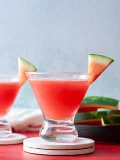 watermelon martini, in glass, in front of sliced watermelon