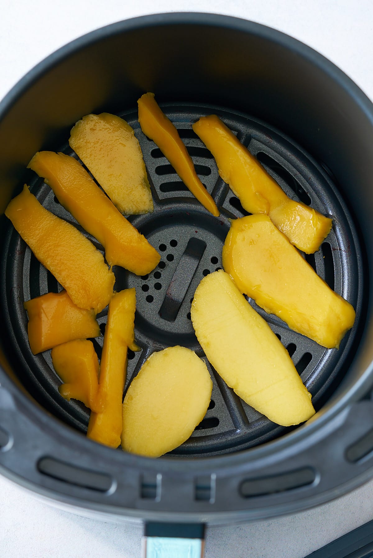 fresh sliced mango in air fryer basket