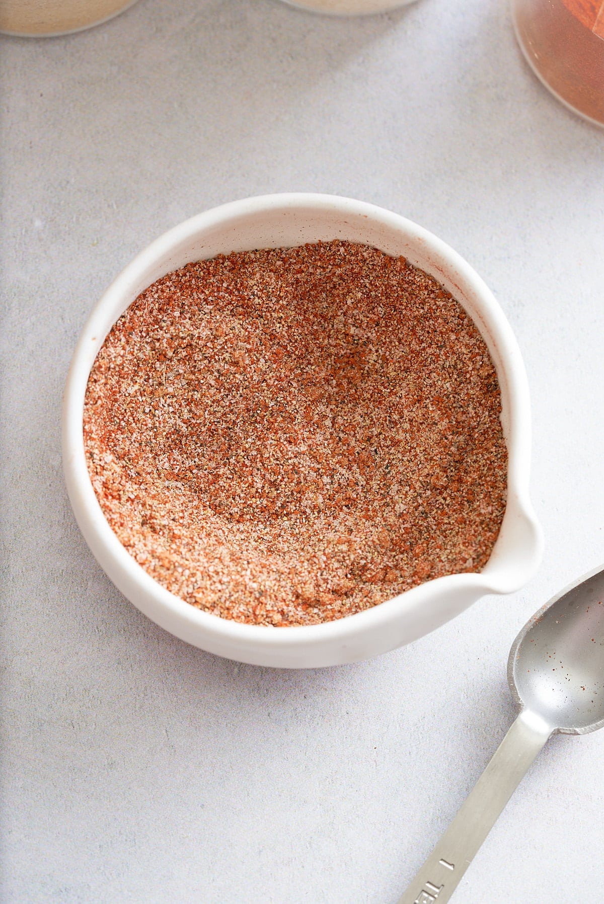 Hamburger seasoning in a small white dish.