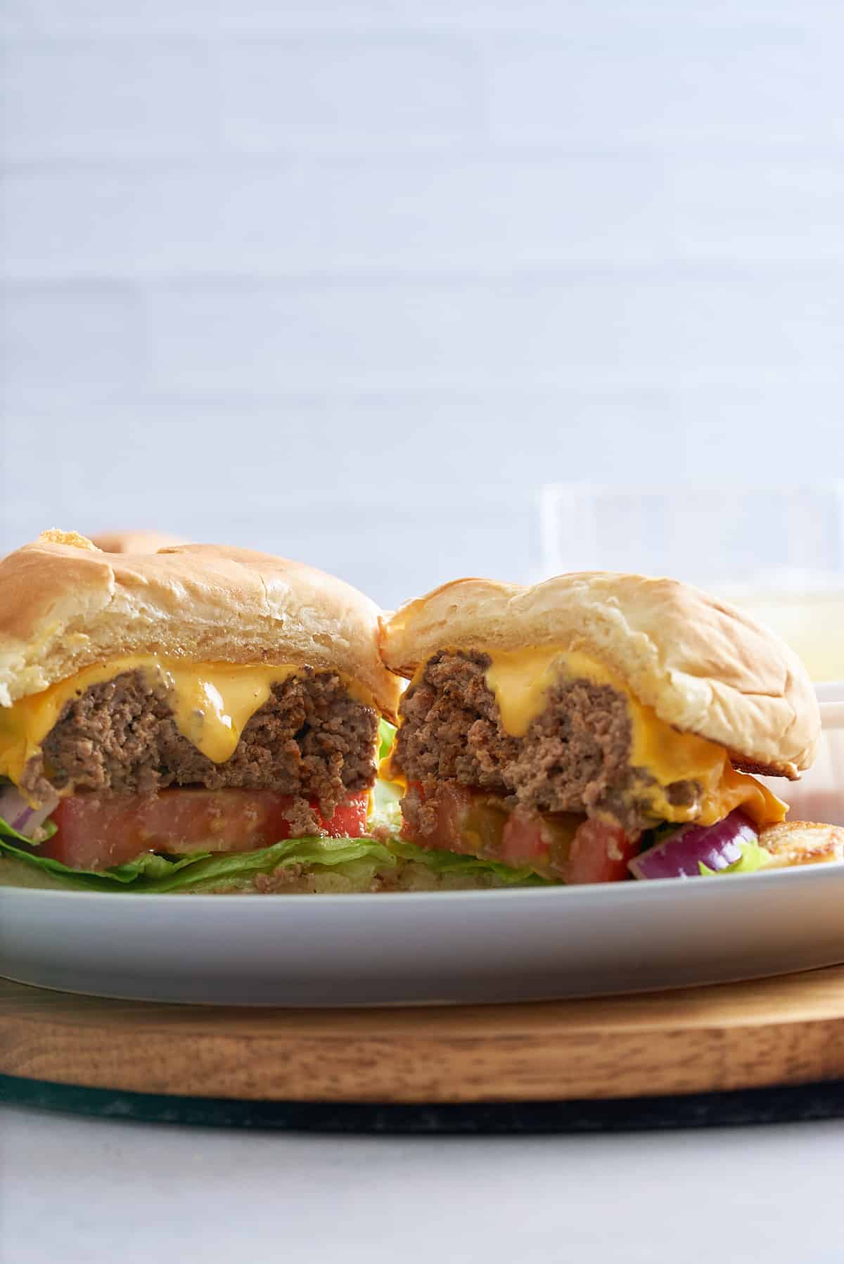 A prepared steamed cheeseburger cut in half.