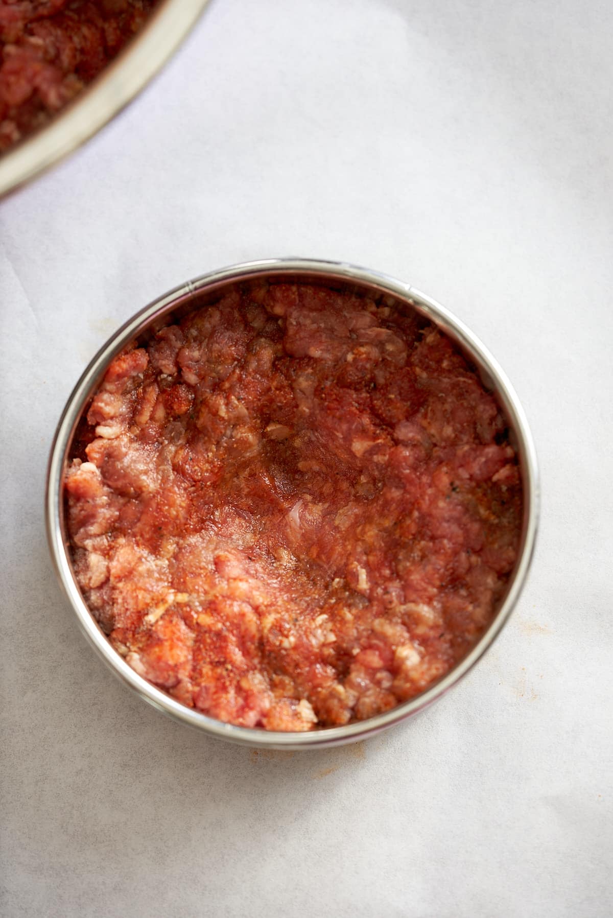 Raw hamburger pressed into a mold.