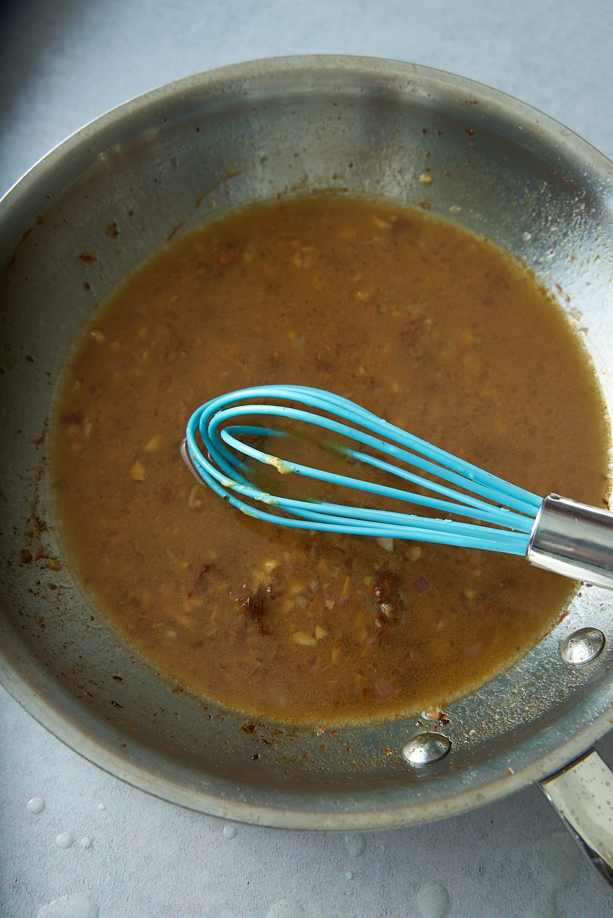 A skillet filled with warm vinaigrette dressing.