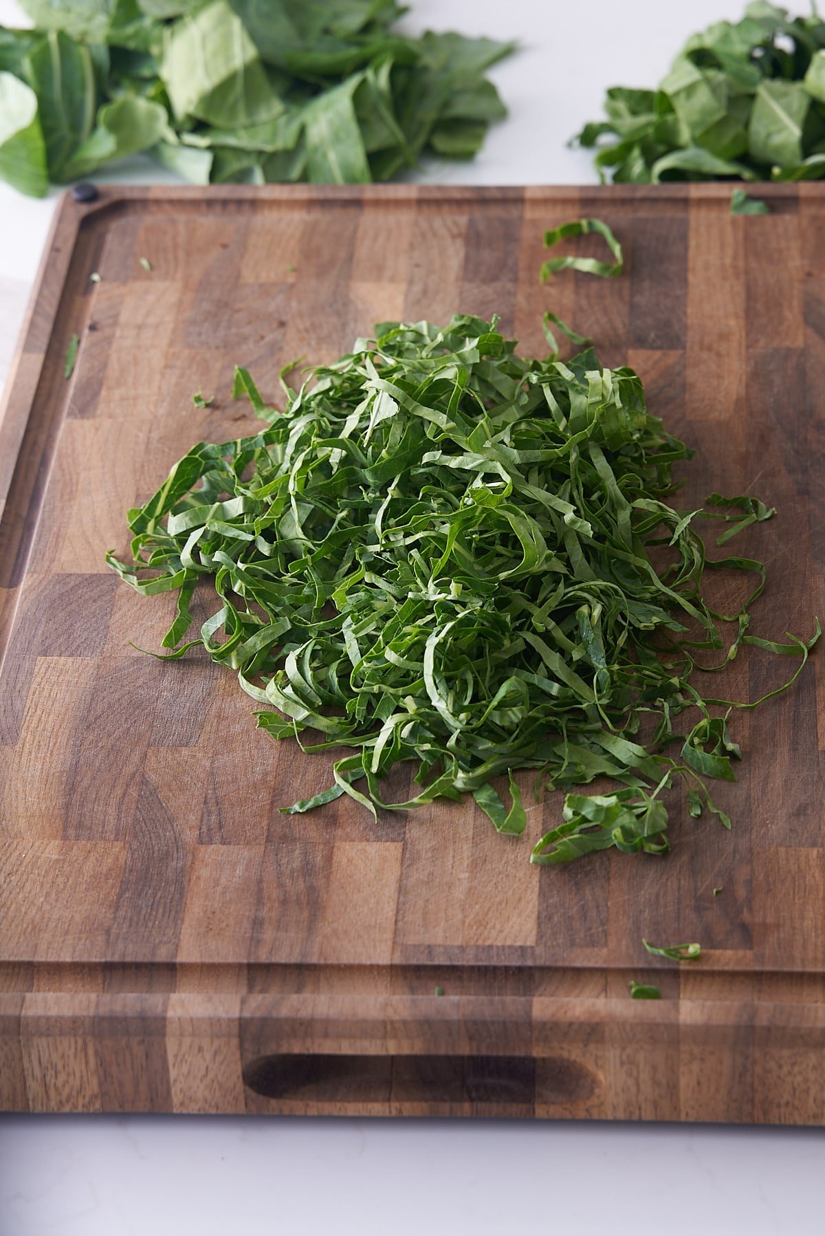 finely shredded collard greens on cutting board