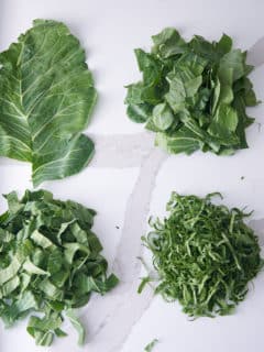 collard greens on white marble countertop. whole leaves, chopped leaves, and sliced leaves