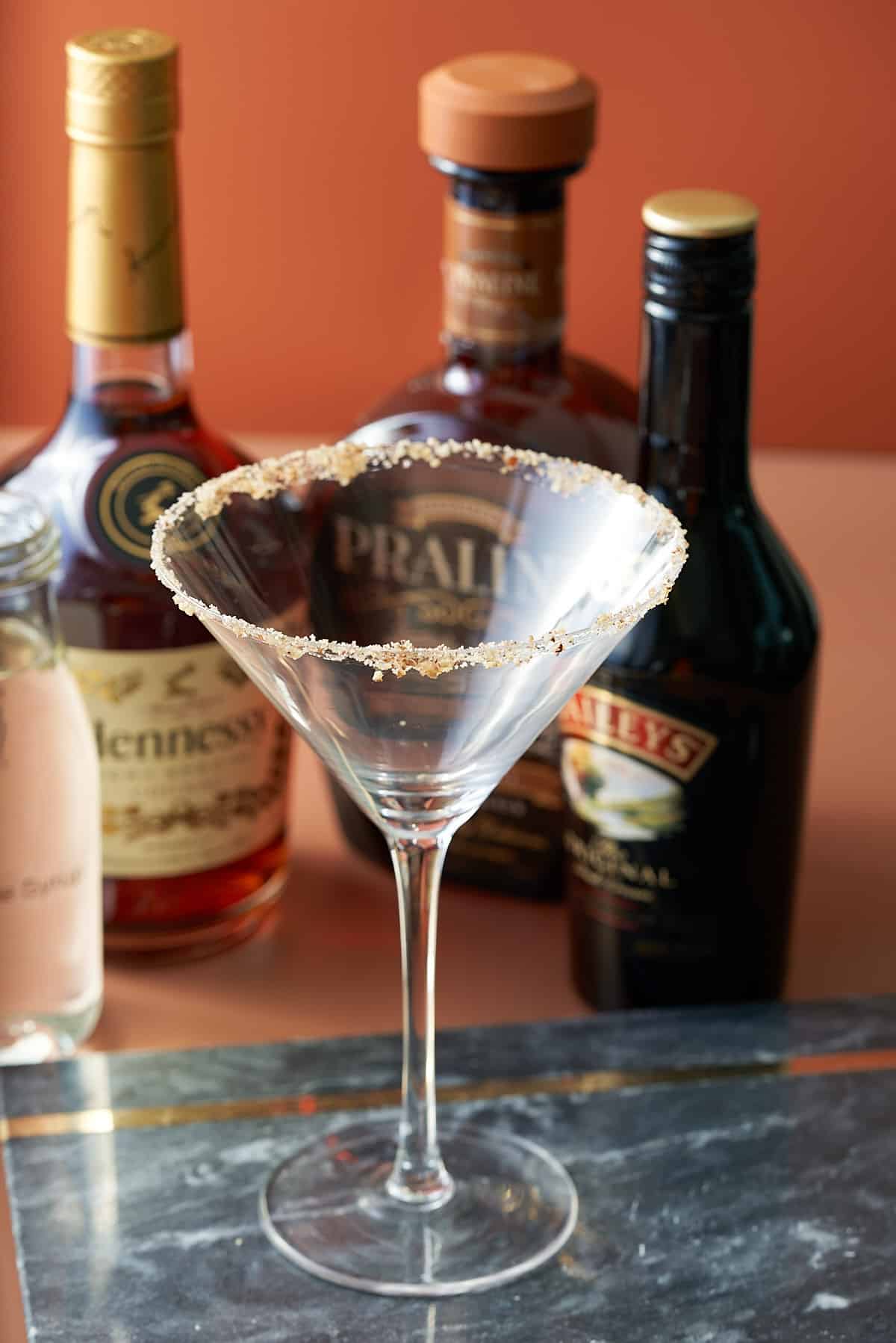 A martini glass rimmed with brown sugar and crushed pecans.