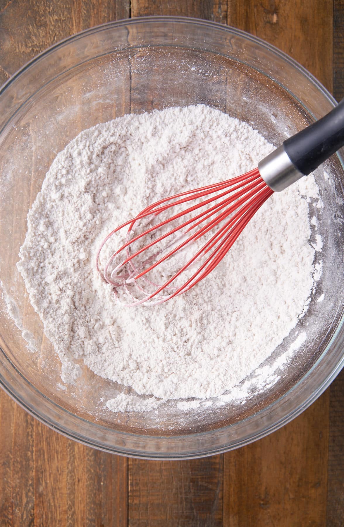 A large mixing bowl filled with flour, baking powder, salt and pumpkin pie spice.