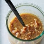 A glass jar filled with warm bacon vinaigrette.