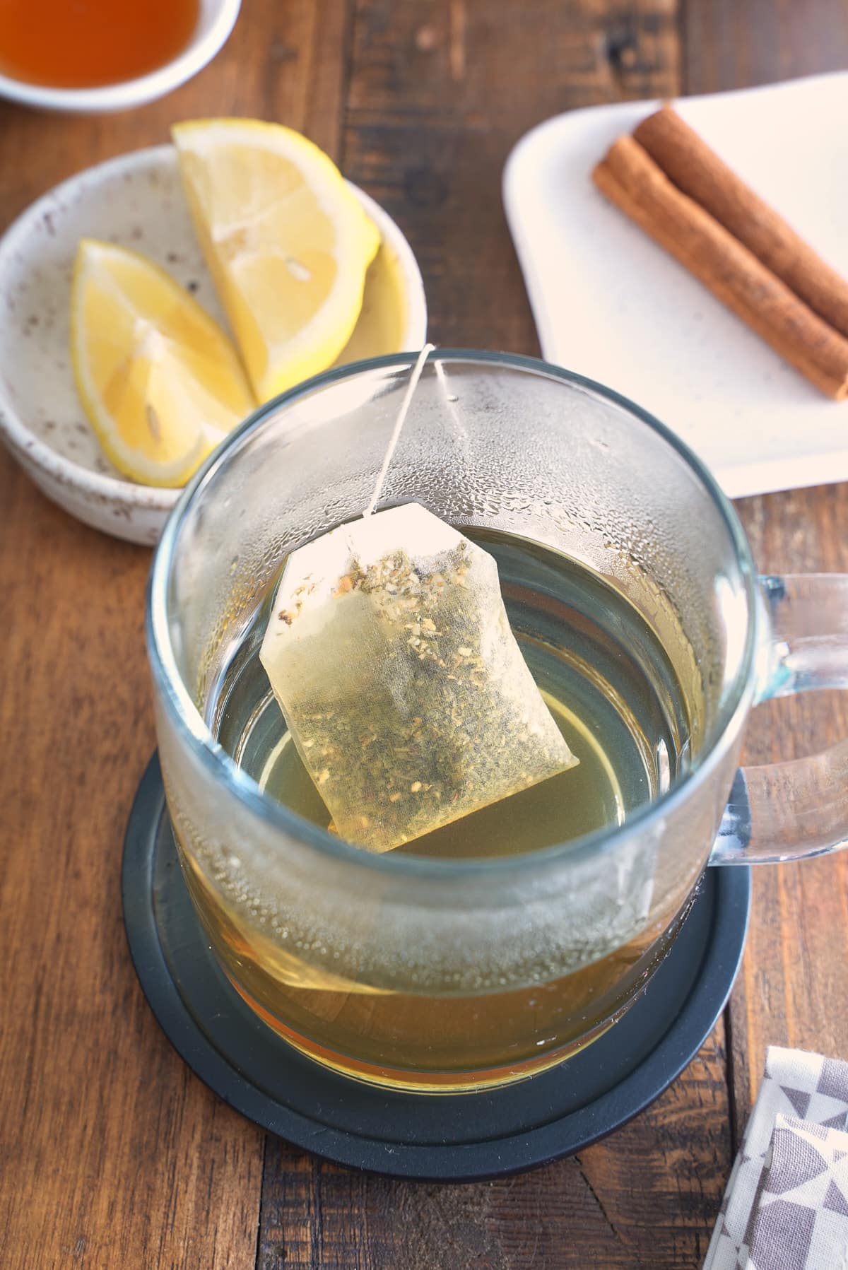 A tea bag steeping in a glass.