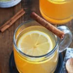 A bourbon hot toddy garnished with a lemon slice and a cinnamon stick.