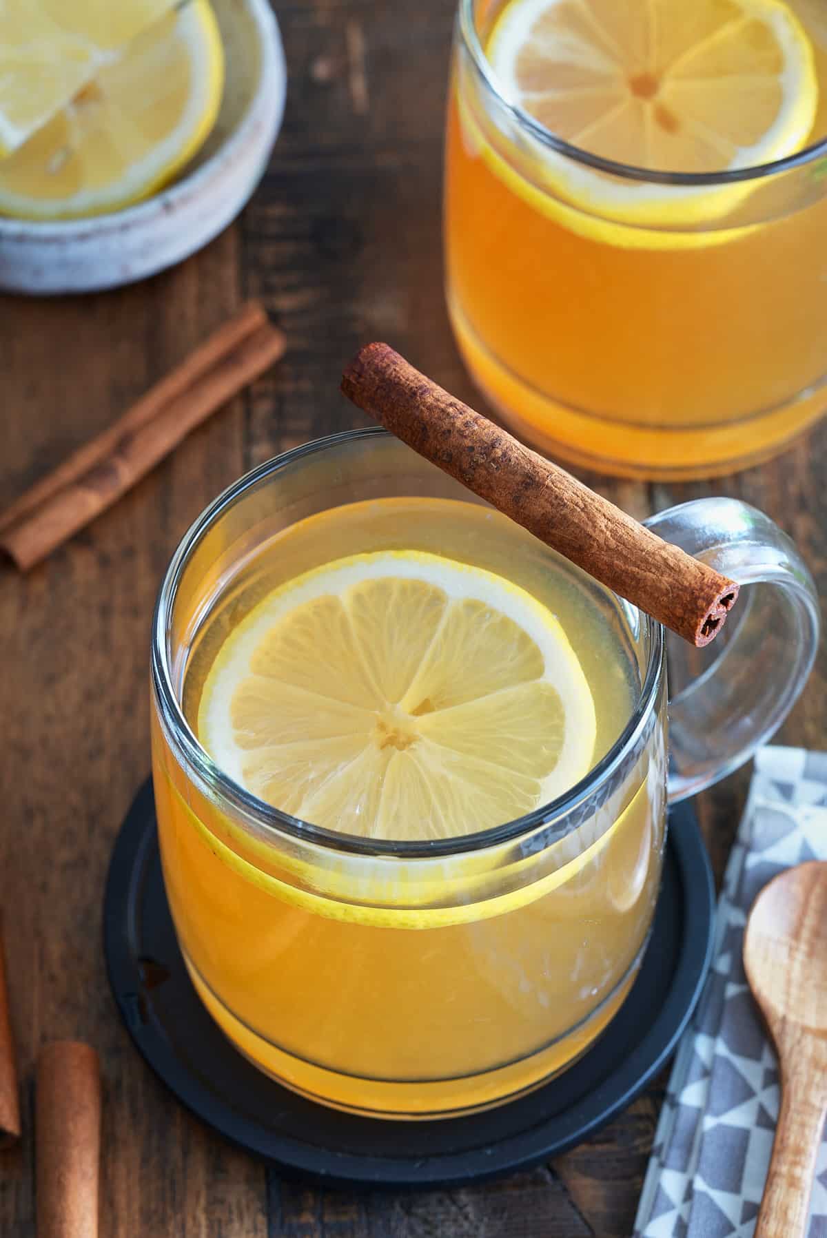 A bourbon hot toddy garnished with a lemon slice and a cinnamon stick.