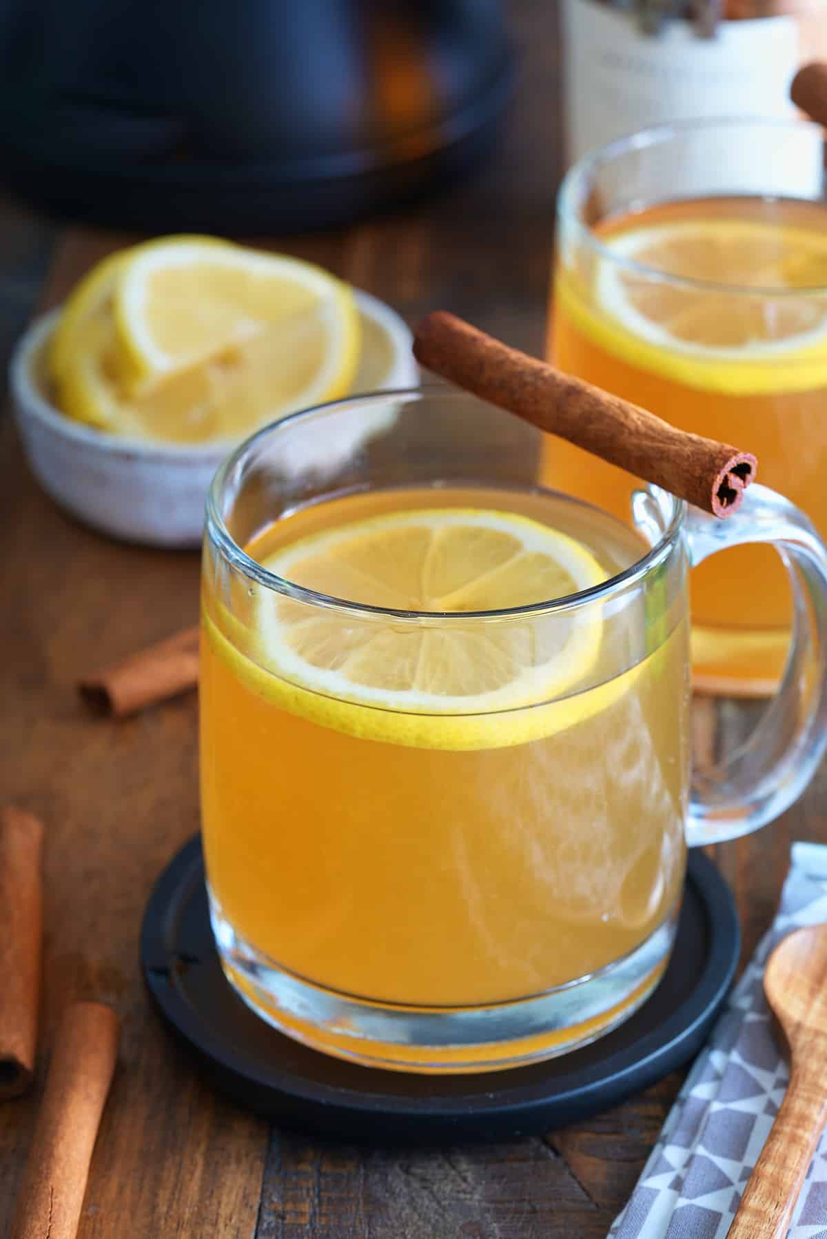 A bourbon hot toddy garnished with a lemon slice and a cinnamon stick.