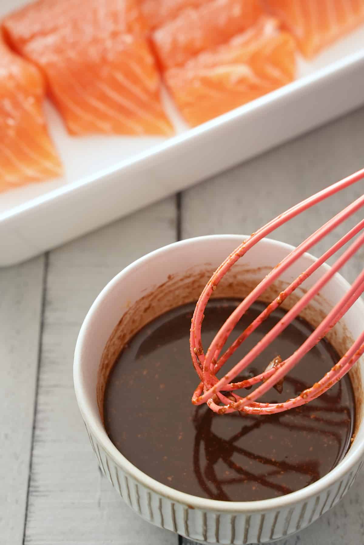 Whisking the marinade together in a bowl.