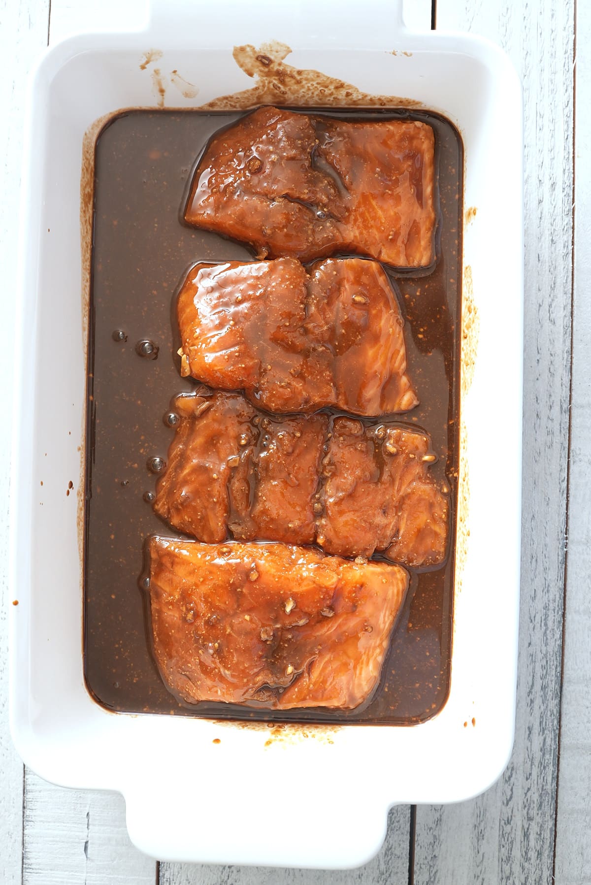 A baking dish with marinating salmon.