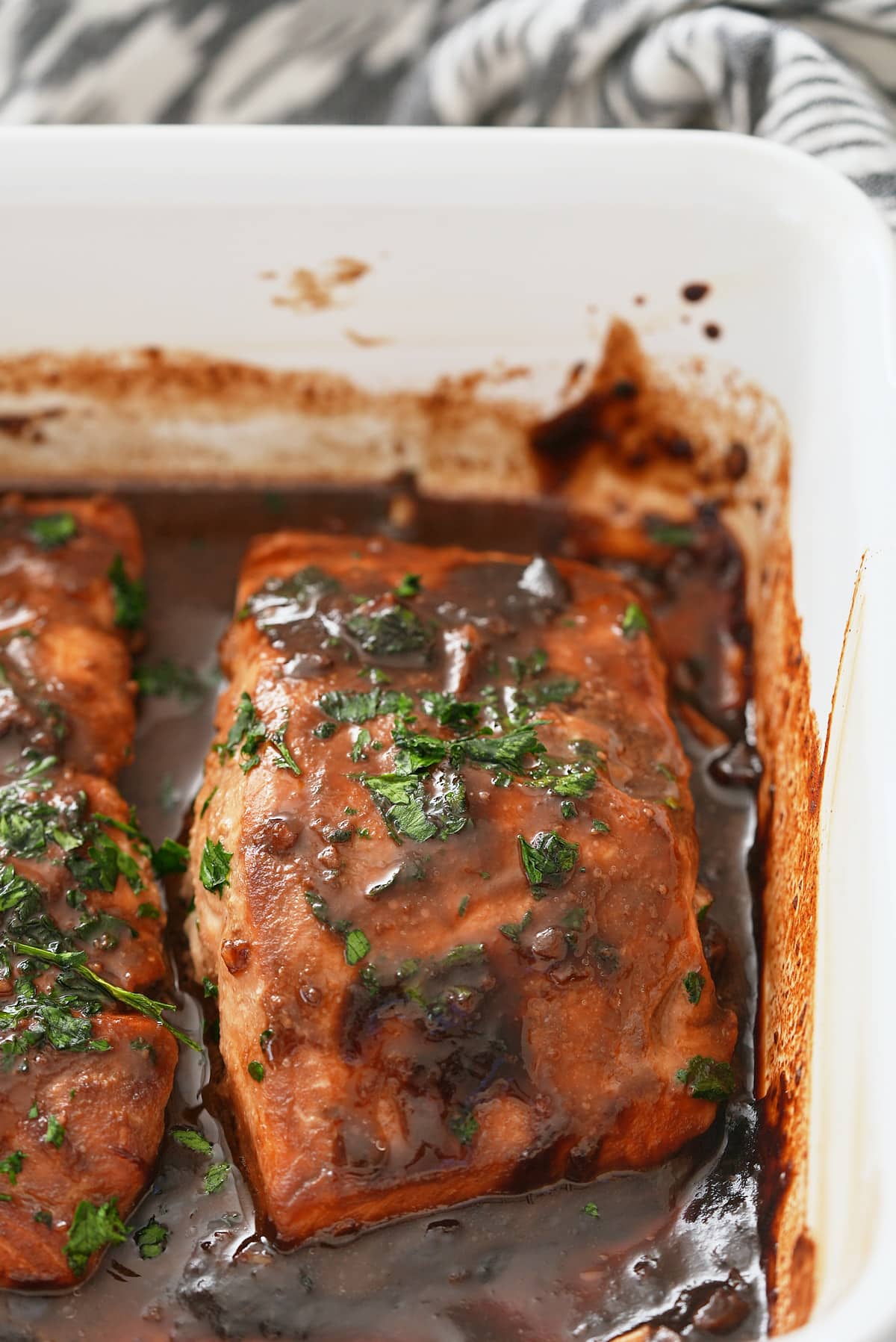 Baked marinated salmon that has been garnished.