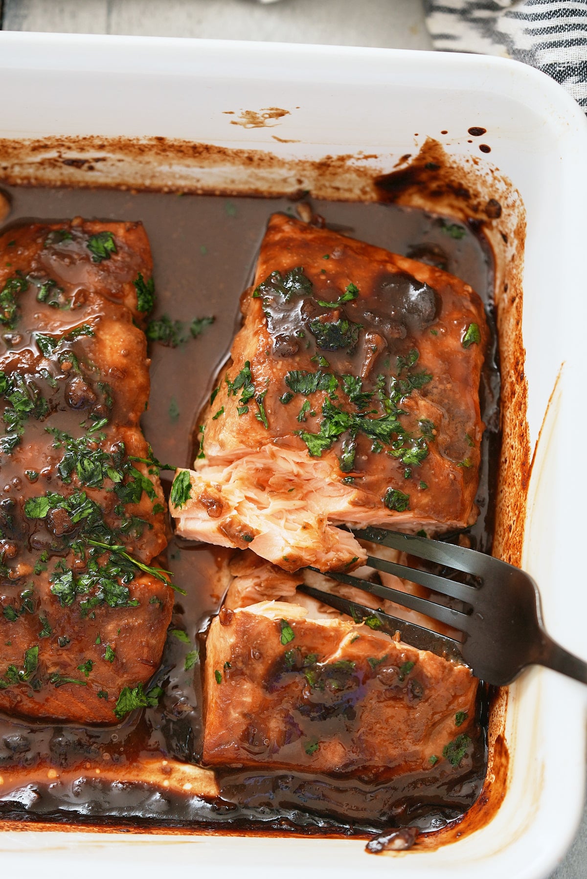 Baked marinated salmon that has been garnished.