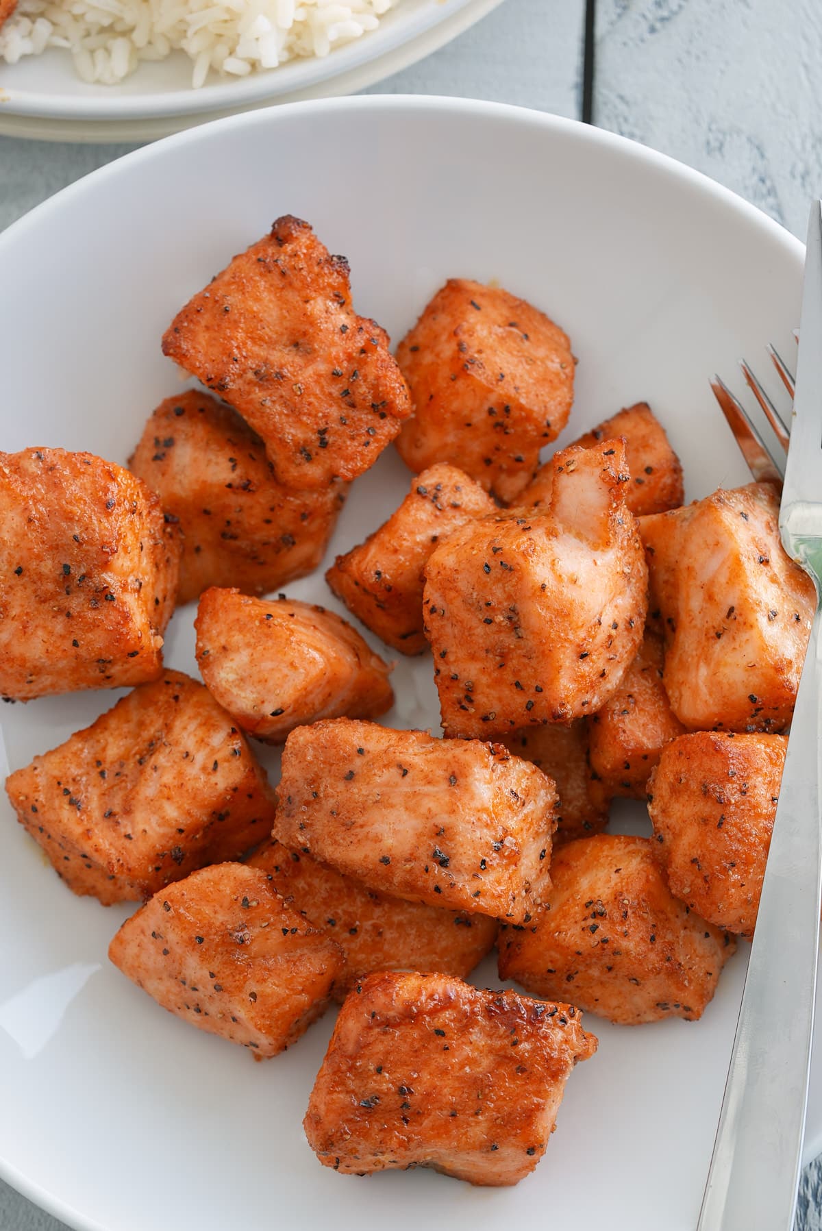 Cubes of cooked salmon coated in salmon seasoning.
