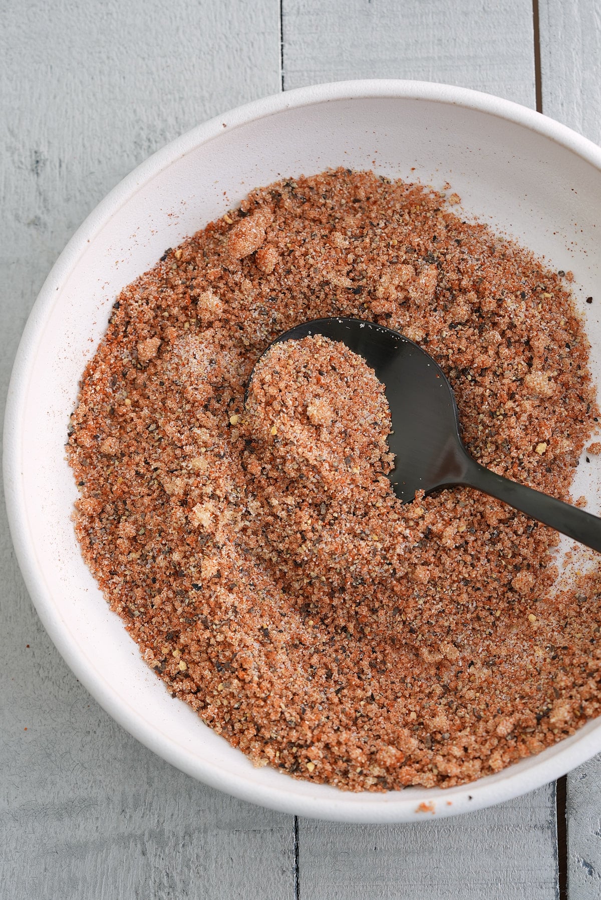 A white bowl with mixed salmon seasoning.