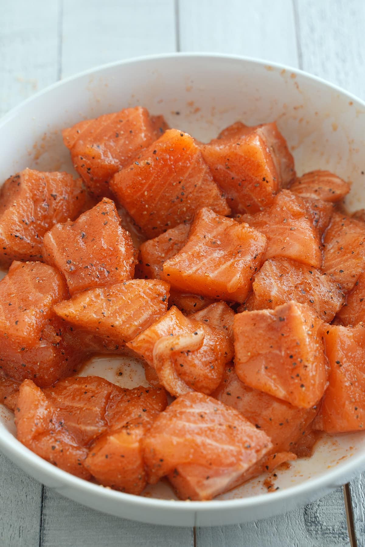 Cubes of raw salmon coated in salmon seasoning.