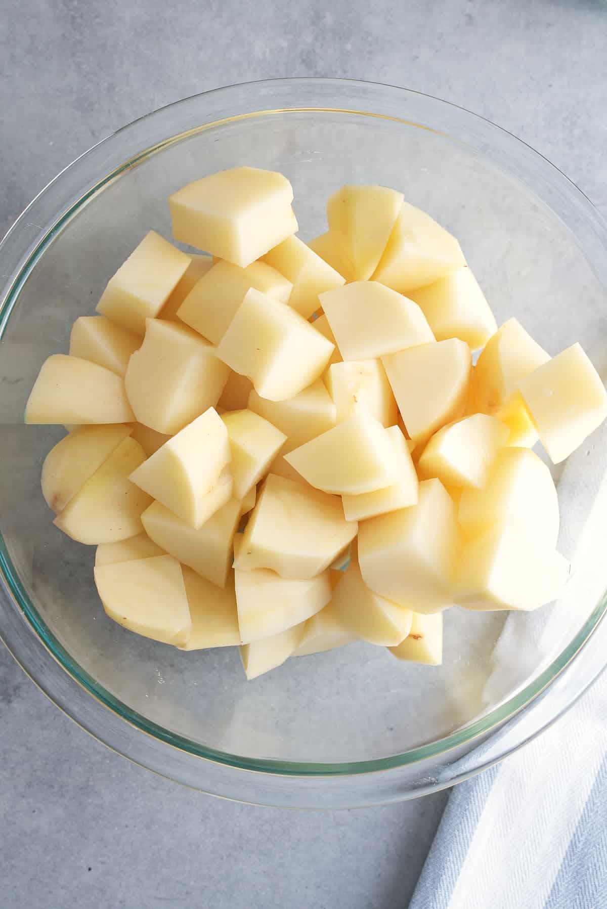 Chopped potatoes in a glass bowl.