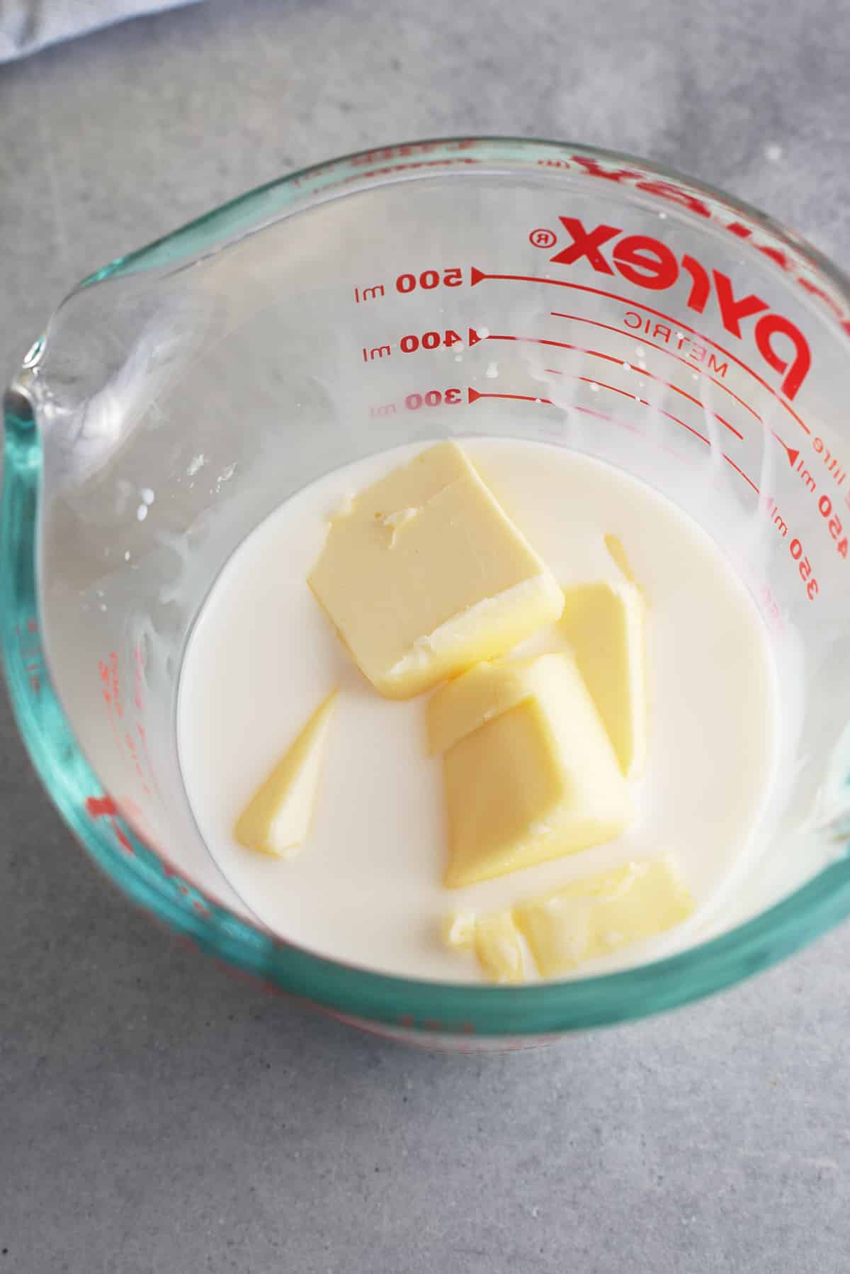 Butter and milk in a glass measuring jug.