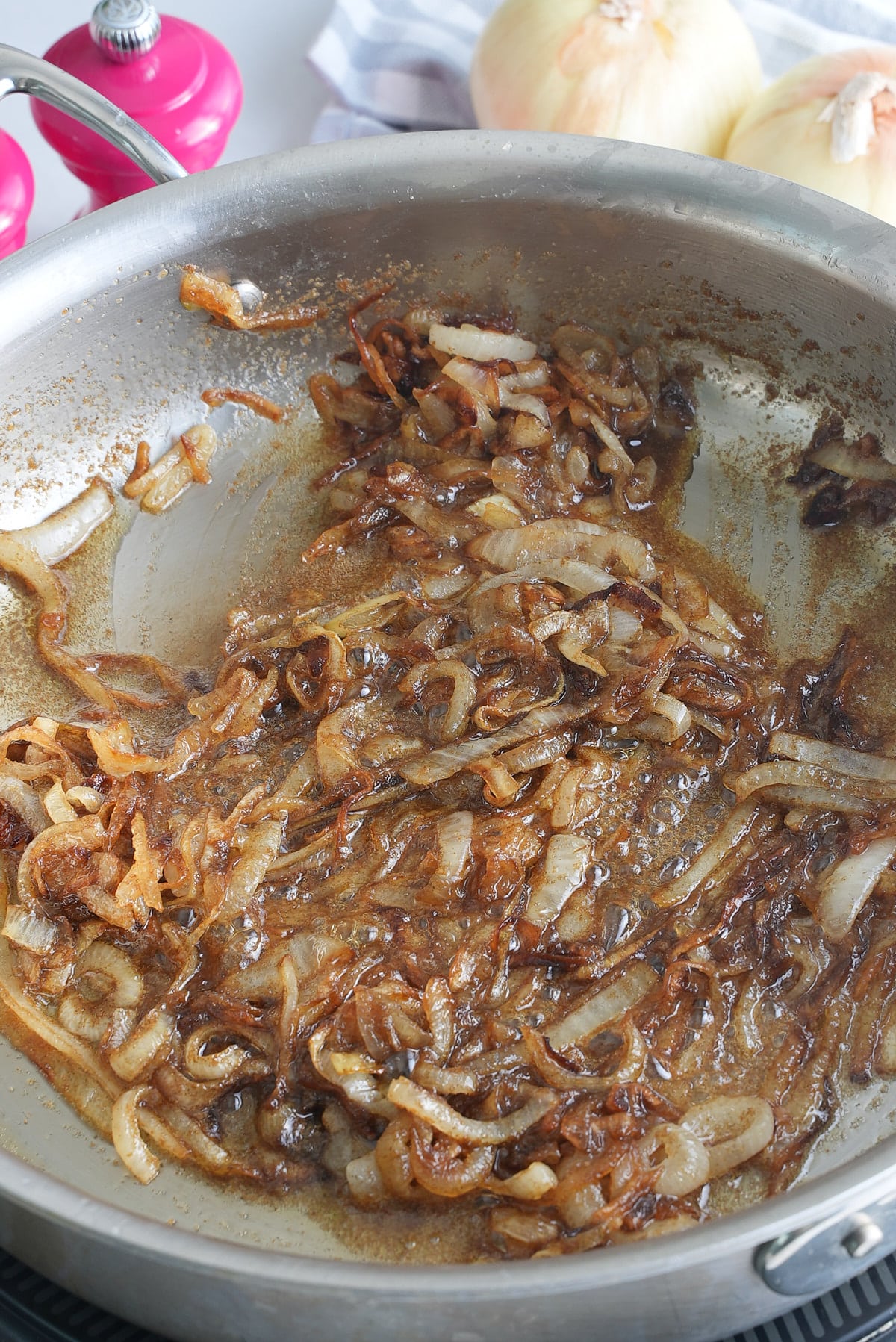 A large skillet with soft and carmelized onions.