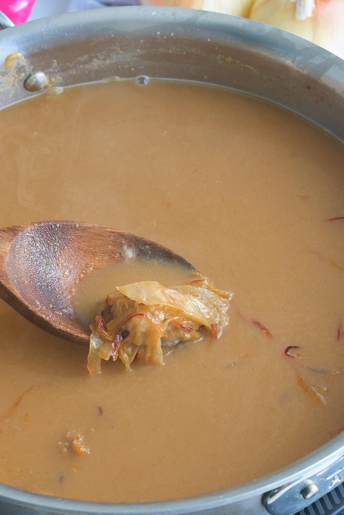 A large skillet filled with onion gravy.