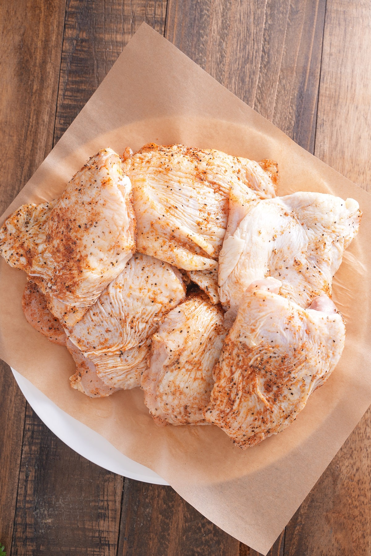 seasoned chicken thighs on parchment paper