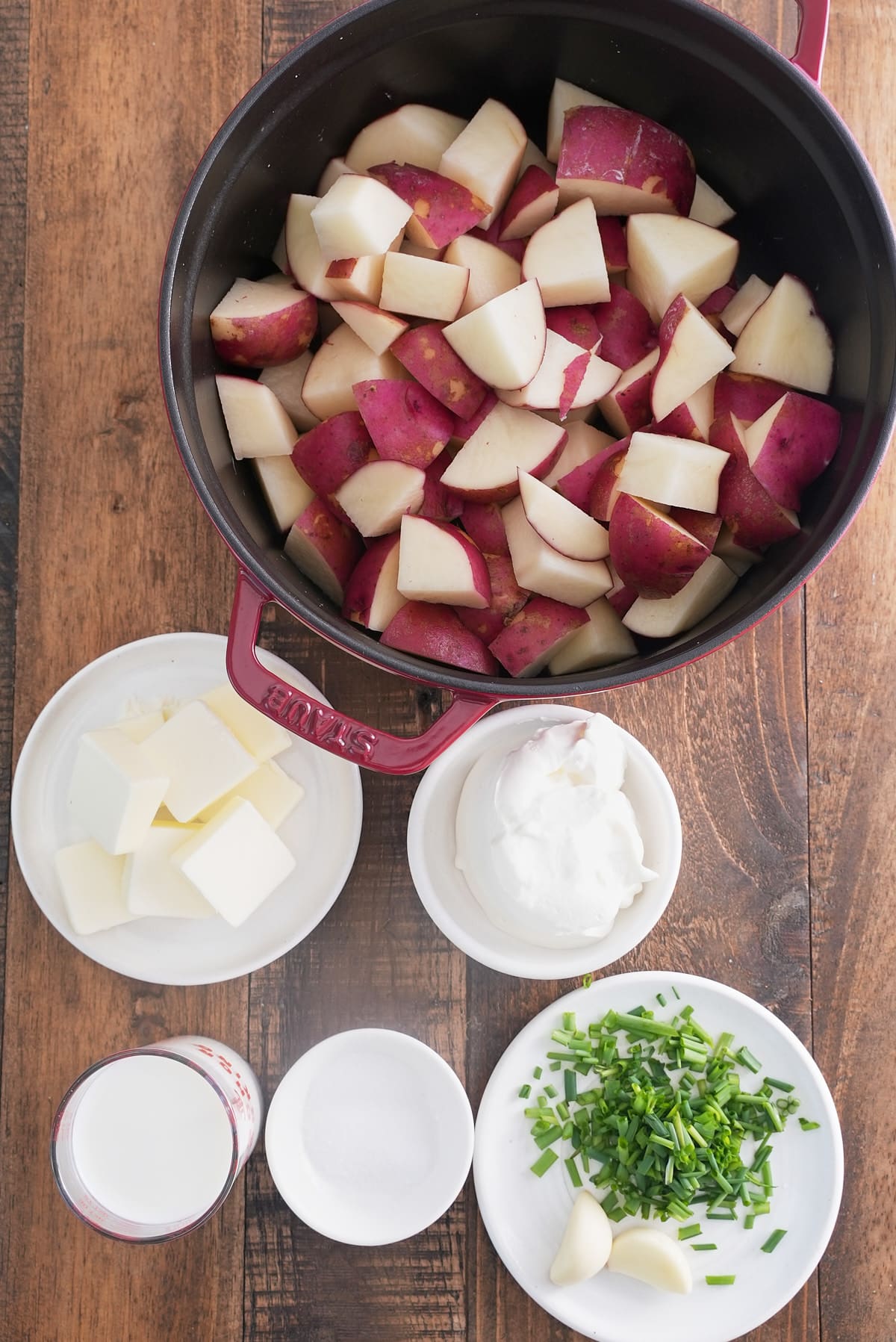 Mashed red skinned potatoes recipe ingredients set into individual bowls.