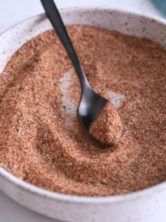 Mixed pork chop seasoning in a white bowl with a spoon.