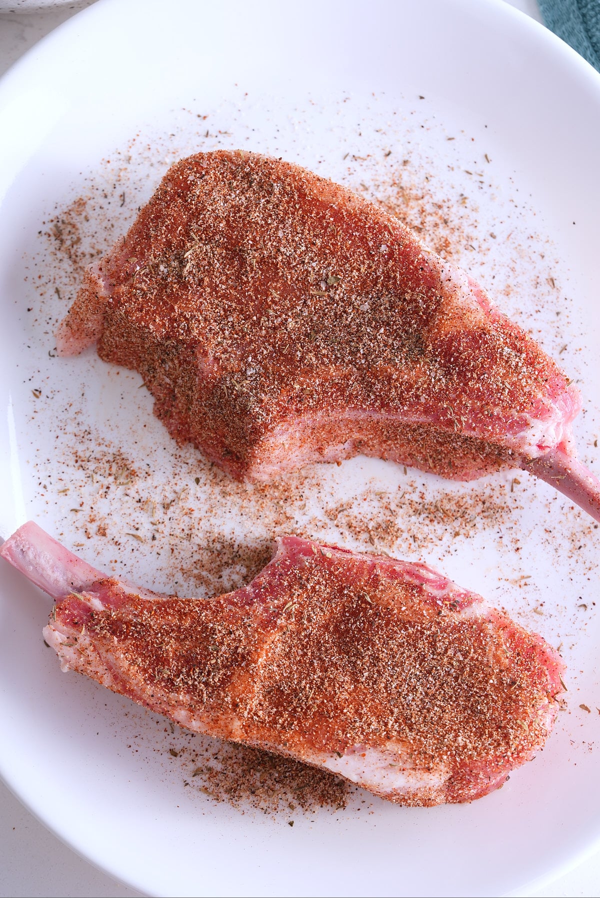 2 pork chops covered in homemade pork chop seasoning.