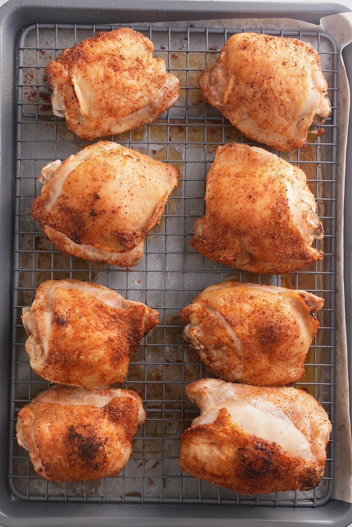 Baked bbq chicken thighs on a baking sheet.