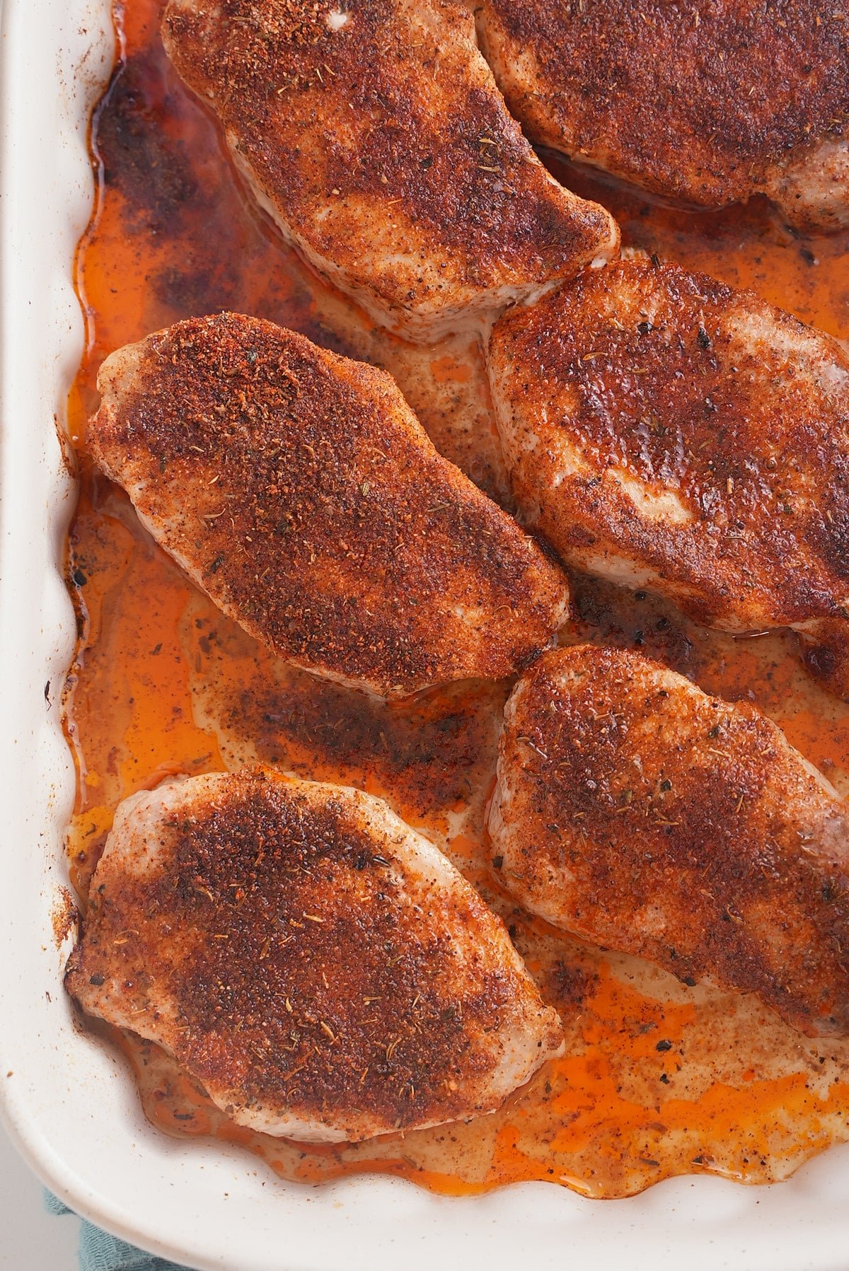 Oven baked pork chops in the baking dish.