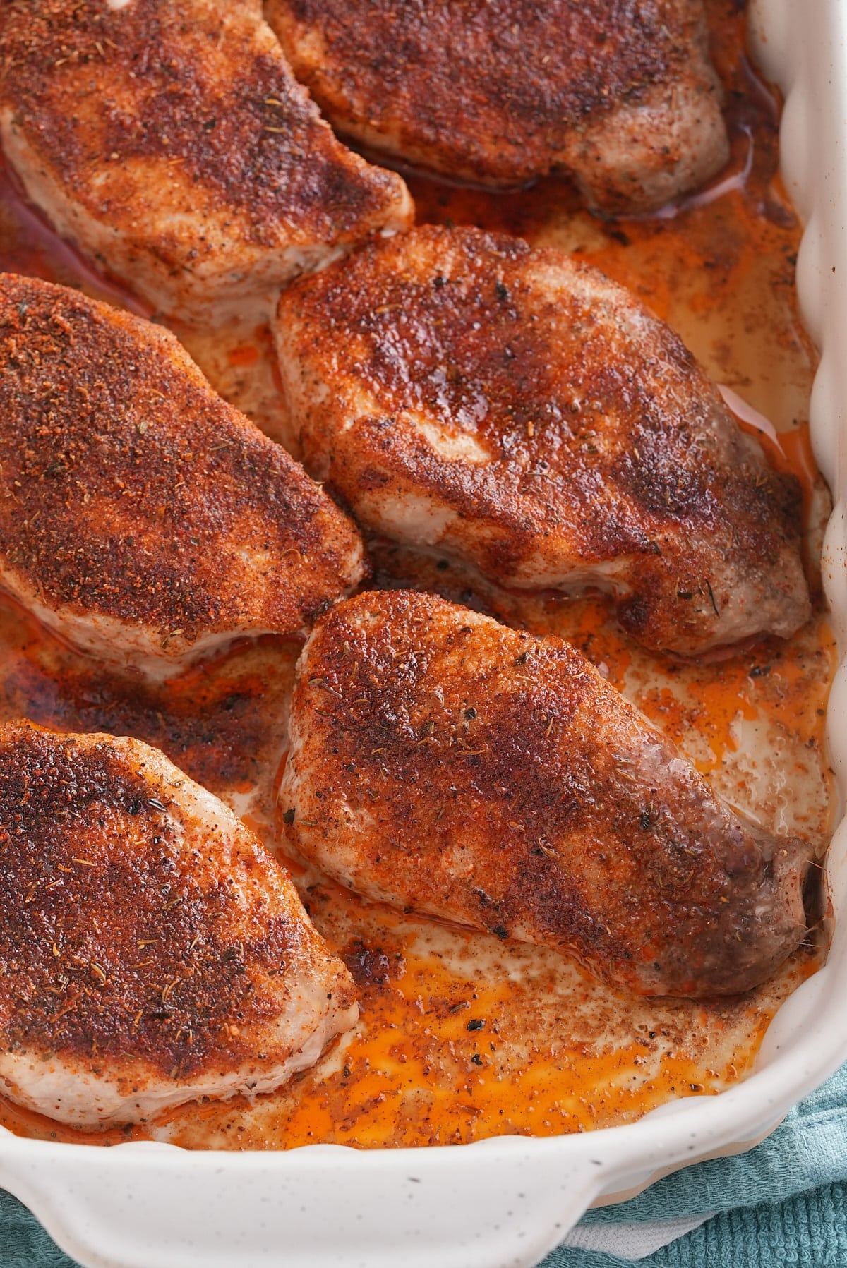 Oven baked pork chops in the baking dish.